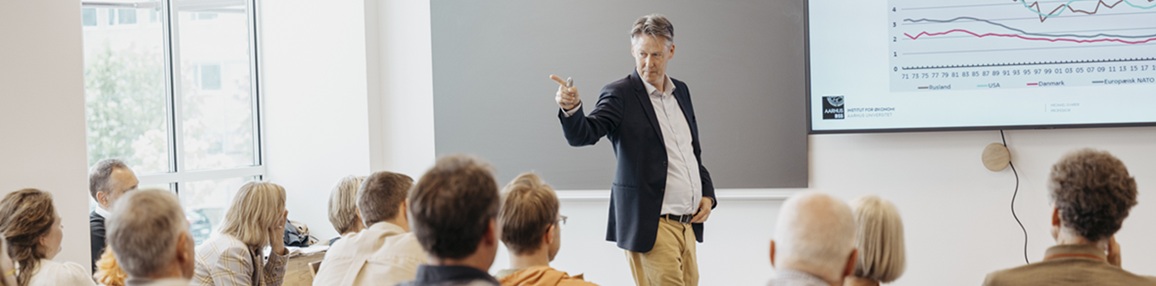 A researcher lecturing in front of a group of people