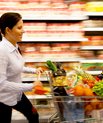 Woman with grocery cart full of groceries.
