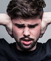 Man holding his hands over his ears Photo: Unsplash